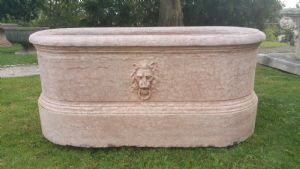 Oval fountain with lion's head in marble